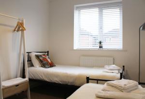 阿宾登Abingdon - Private Flat with Garden & Parking 01的一间卧室设有两张床,窗户设有百叶窗