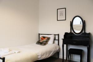 阿宾登Abingdon - Private Flat with Garden & Parking 01的一间卧室配有一张床、镜子和椅子