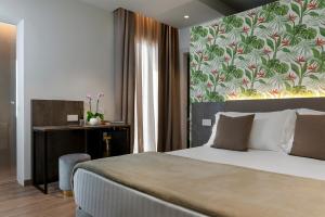 加比切马莱Civico25 Suite Hotel的一间卧室配有一张床和一张带墙壁的书桌