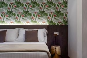 加比切马莱Civico25 Suite Hotel的一间卧室配有一张带花卉壁纸的床