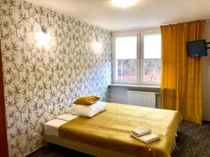 比亚韦斯托克索斯诺维扎西斯泽公寓式酒店的卧室配有一张床铺,位于带墙壁的房间