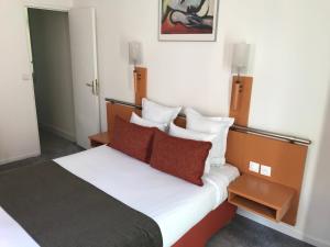 鲁昂莫朗酒店的一间卧室配有带白色床单和红色枕头的床。