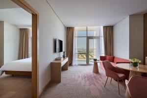 迪拜Novotel Jumeirah Village Triangle的酒店客房带一张床,还有一间景观房