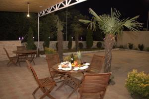 第比利斯Hotel Agava的一个带桌椅和棕榈树的庭院