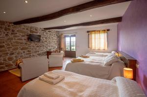 潘通奥坎托达特拉乡村民宿的一间卧室设有两张床和石墙