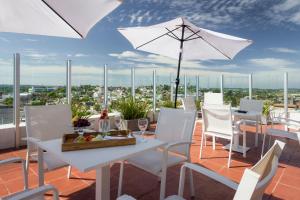 里韦拉Frontier Hotel Rivera的庭院配有白色的桌椅和遮阳伞。