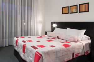 弗赖本托斯弗赖本托斯格兰酒店的一间卧室配有一张带红白色棉被的床