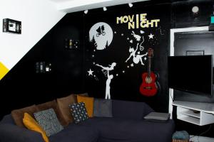 牛津背包客中央旅馆的客厅配有沙发和带月亮及吉他墙