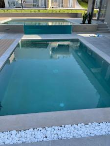 普拉塔尼亚斯Twins Apartments的拥有蓝色海水和白色岩石的游泳池