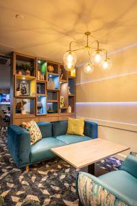 伦敦伦敦假日宾馆 - 摄政公园的客厅配有蓝色的沙发和桌子