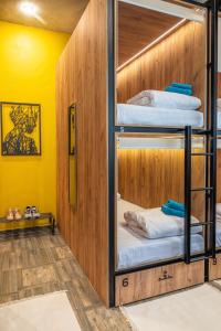 索契HiLoft Hostel的一间设有双层床的客房,拥有黄色的墙壁