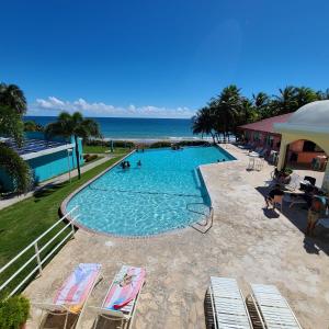 毛纳沃帕拉多马纳卡瑞比-马纳博的一个带椅子的游泳池,背景是大海