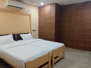 加尔各答Soukyam Hotel的一间卧室配有一张床,墙上配有投影仪