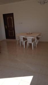 Madain Salehشاليه الفاخريه的一张桌子和两张白色椅子,位于一个有门的房间