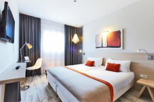 瓦讷基利雅得卓越瓦纳中心 - 万国宫艺术酒店的酒店客房设有一张大床和一张书桌。