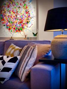 克诺克－海斯特Appartement Sunny home Deluxe的一张带枕头的紫色沙发以及一张桌子上的台灯