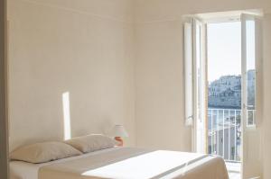 维耶斯泰Casa Pinta Rooms的白色的卧室设有床和大窗户