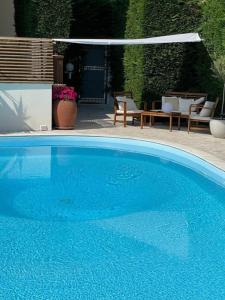 阿尔比索拉马里纳Casa Milena elegante dimora con piscina privata的一个带桌椅的大型蓝色游泳池