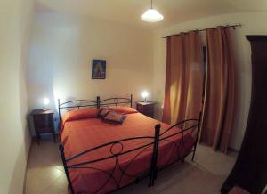 兰佩杜萨Borgo Il Faro的一间卧室配有一张带橙色床罩的床