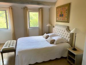 鲁西永玫瑰别墅酒店的卧室配有一张白色大床和两个窗户