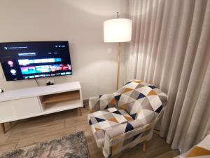 比勒陀利亚Regency Apartment Hotel Menlyn的客厅配有椅子和平面电视