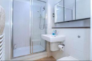 格拉斯哥Oswald Apartment - Glasgow City Centre的带淋浴和盥洗盆的白色浴室