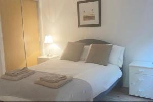 格拉斯哥Oswald Apartment - Glasgow City Centre的卧室配有白色的床和2条毛巾