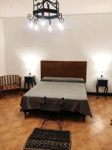萨尔塔Petit Deluxe Salta的一间卧室配有一张床、两张桌子和两盏灯。
