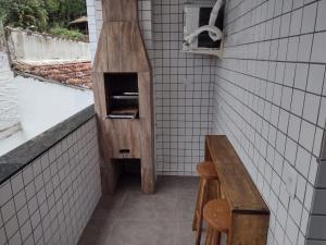 乌巴图巴Apartamento Cereja do Mar的厨房配有长凳和比萨饼烤箱