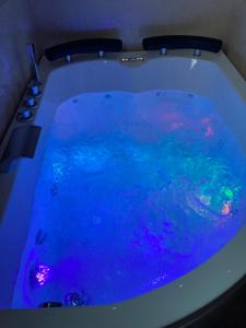 卡塞塔B&B LA REGGIA DI RIHANNA spa的浴缸里装满蓝色的海水,配有灯光