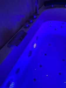 卡塞塔B&B LA REGGIA DI RIHANNA spa的暗室设有蓝色灯光浴缸