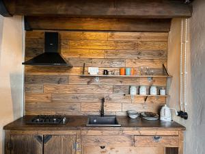 卡兹贝吉Elia Loft的厨房设有木墙和炉灶