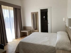 罗马Hotel Nova Domus Aurelia的卧室配有白色的床和窗户。