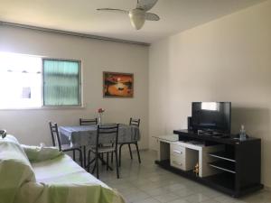 阿拉卡茹Mar Azul Condomínio的一间卧室配有一张床和一张桌子及一台电视