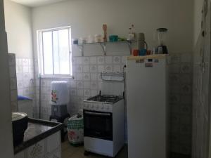 阿拉卡茹Mar Azul Condomínio的厨房配有炉灶和白色冰箱。