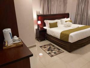 卡萨内Top Stay Inn的酒店客房配有一张床铺和一张桌子。