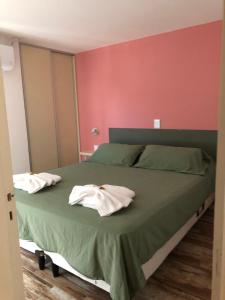 维拉卡洛斯帕兹Los Naranjos Apart Hotel的一间卧室配有一张床,上面有两条毛巾