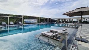 马尼拉Hotel Okura Manila - Staycation Approved的一个带椅子和遮阳伞的游泳池