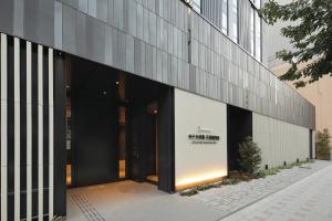 大阪Hotel Keihan Tenmabashi Ekimae的享有带大型玻璃门的建筑的外部景色