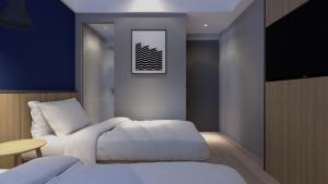 雅加达LeGreen Suite Sudirman的一间卧室配有两张床和电视。