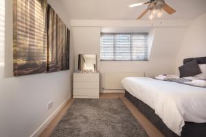 朴次茅斯BEST PRICE! LARGE HOME FOR 4 - SMART TV - COMFY BEDS - GARDEN - 4 Single Beds or 2 Doubles!的一间卧室配有一张床和吊扇