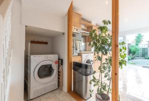 朴次茅斯BEST PRICE! LARGE HOME FOR 4 - SMART TV - COMFY BEDS - GARDEN - 4 Single Beds or 2 Doubles!的洗衣房配有洗衣机、烘干机和植物