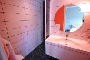 LʼHorme伏尔甘酒店的粉红色的浴室设有水槽和镜子