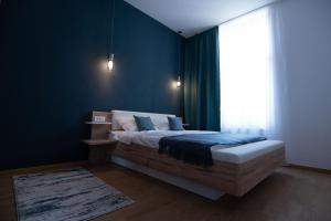 弗格拉什Urban Six Apartments的一间卧室配有一张蓝色墙壁的床和一扇窗户