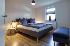 弗伦斯堡Fördepause的一间卧室配有一张带蓝色枕头的床和一扇窗户。