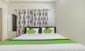 博帕尔Treebo Trend Alankar Hoshangabad Road的一间卧室配有白色的床和绿色和黄色枕头