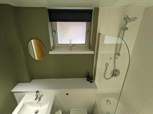 米德尔斯伯勒Middlehaven Studio的带淋浴、盥洗盆和镜子的浴室