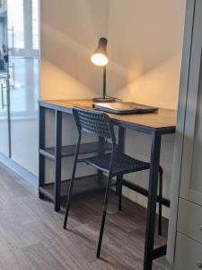 米德尔斯伯勒Middlehaven Studio的一张桌子,上面有椅子和一盏灯