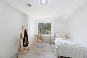 肯图巴Cliff Haven Retreat的一间卧室配有一张床、一张书桌和一个窗户。