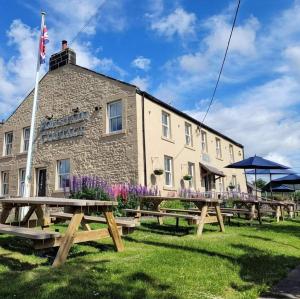 贝灵汉姆Fountain Cottage, Bellingham, Northumberland的前面设有野餐桌的建筑